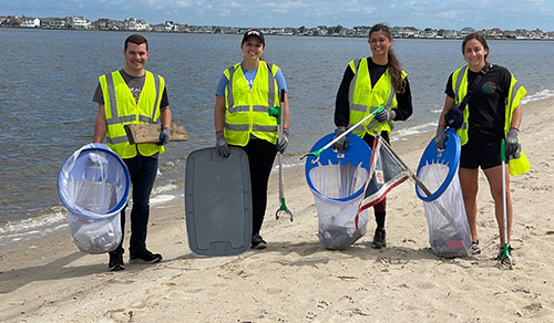 group of people cleaning beach